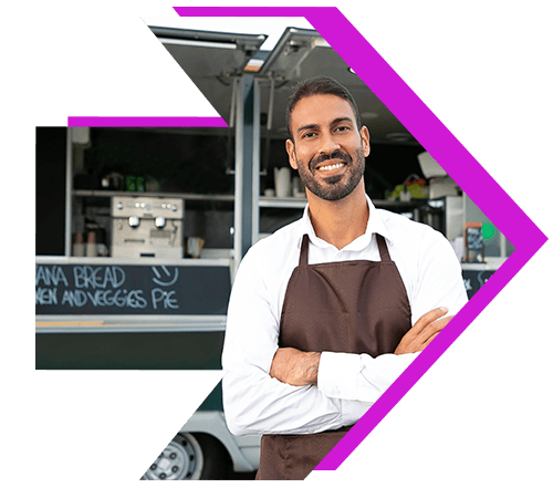 Food truck owner standing in front of truck smiling